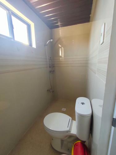 卡利博JM's BnB Hauz Air-conditioned private room的一间带白色卫生间的浴室和窗户。