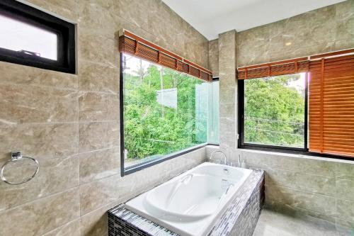 班邦宝Sea VIEW POOL Villa - 8 peoples- Private Pool - Beautiful garden的带浴缸的浴室和窗户。