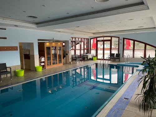 沙托劳尔尧乌伊海伊Hotel Hunor的一座大型游泳池,位于一座带窗户的建筑内
