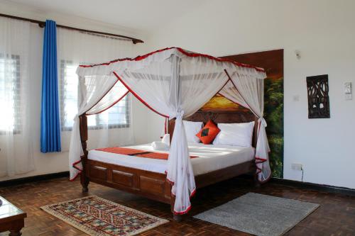 蒙巴萨Maasai Villas的一间卧室配有一张带天蓬的床