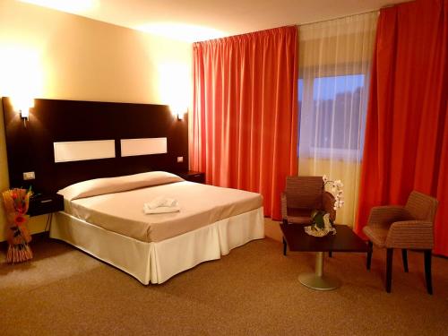 TitoSanta Loja Hotel Residence的配有一张床和一把椅子的酒店客房