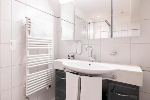 苏黎世EMA House Serviced Apartments Seefeld的白色的浴室设有水槽和镜子