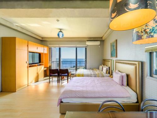 西归浦市OROJEJU的一间卧室配有一张床,享有海景