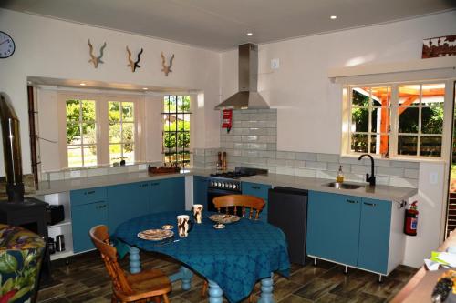 霍维克The Corner House Sa的厨房配有蓝色橱柜和蓝色的桌椅
