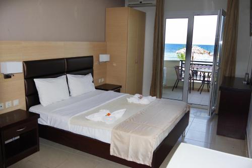斯卡拉拉乔伊Rachoni Resort的一间卧室设有一张床和一个海景阳台