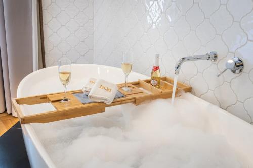 布达佩斯Budapest Eye- Boutique Suites, by BQA的浴缸配有葡萄酒和香槟托盘