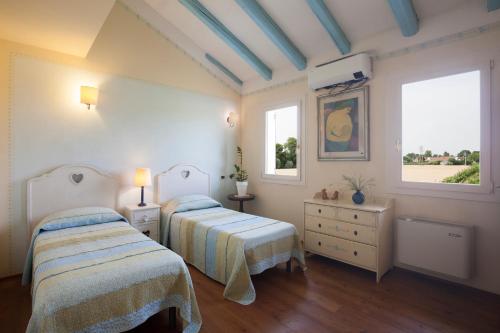 米拉诺COUNTRY HOUSE CASAMIRIAM的一间卧室设有两张床和两个窗户。