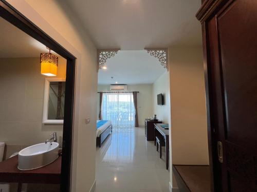 甲米镇甲米湾前度假酒店的一间带水槽的浴室和一张位于客房内的床