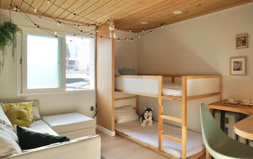 首尔Mapo Rooftop camping house的客房设有双层床、沙发和桌子。
