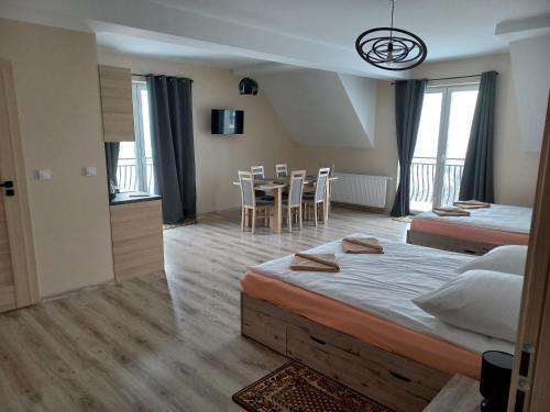 克鲁斯兹考采Apartamenty Na Rozstaju的一间卧室配有两张床和一张桌子及椅子