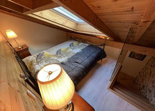 内顿斯La Ferme aux Diligences的小型阁楼卧室配有床和灯