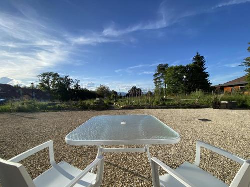 内顿斯La Ferme aux Diligences的一张桌子和椅子,坐在砾石堆院里