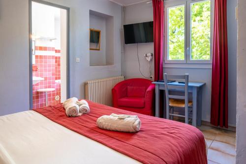 维勒克罗兹Au Bien Etre piscine的一间卧室配有一张带红色毯子和红色椅子的床