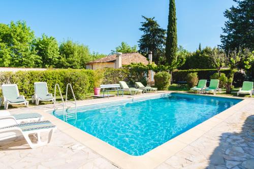 维勒克罗兹Au Bien Etre piscine的一个带躺椅的游泳池以及一座房子