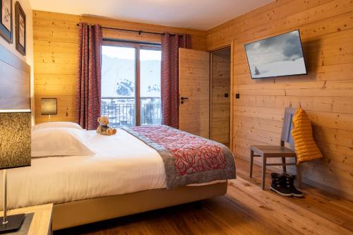 拉普拉涅CGH Résidences & Spas White Pearl Lodge的一间卧室,床上有泰迪熊