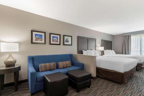 圣安东尼奥康福特旅馆&套房靠近医疗中心的酒店客房,配有床和蓝色的沙发