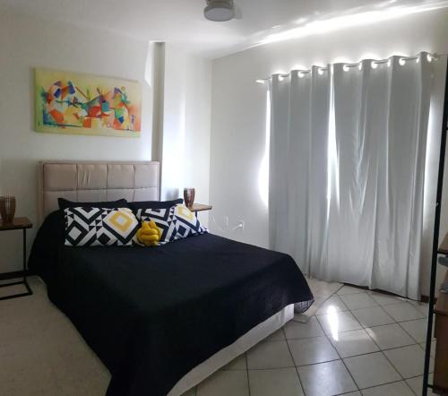 邦比尼亚斯Hermoso departamento en Bombas con vista al mar的一间卧室配有黑色的床和白色窗帘