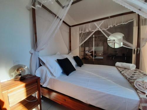 阿格德角VILLA RASOA chambre NOSY BE的卧室配有白色的床和木桌