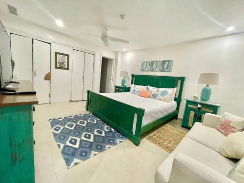 Juan Pedro2 Bedroom At The Marbella Towers Beachfront的一间卧室配有绿色的床和沙发