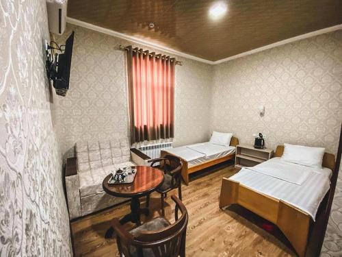 希瓦Polvon Ota Hotel的一间设有两张床和一张桌子的房间