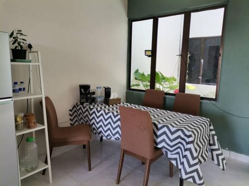 马六甲Eng Ban Hin guesthouse的一间带桌椅和窗户的用餐室