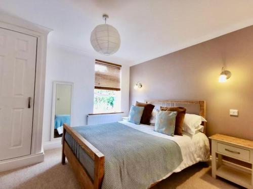 卡比斯贝Sandsifter at 4 Trencrom Court, Carbis Bay,St Ives, Cornwall的一间卧室设有一张大床和一个窗户。