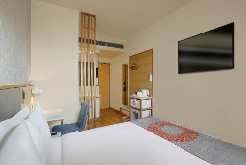 古尔冈Holiday Inn Express Gurugram Sector 50, an IHG Hotel的一间卧室配有一张床、一张桌子和一把椅子