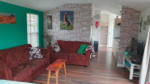 斯赫拉芬赞德dutchduochalet13的客厅设有红色沙发和砖墙