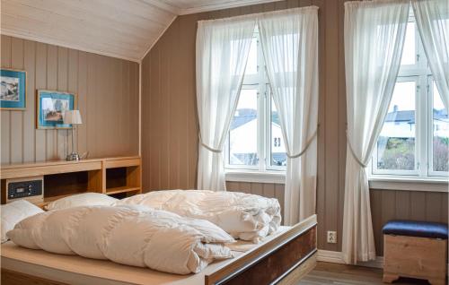 Bekkjarvik4 Bedroom Nice Home In Bekkjarvik的一间卧室配有一张带白色床单和窗户的床。