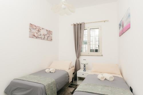 佩斯科勒海滨Pescoluse Houses的一间卧室设有两张床和窗户。