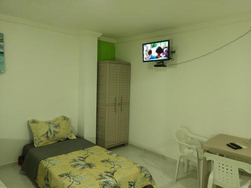 圣安德烈斯LodgeFabi'sPlace的卧室配有一张床,墙上配有电视。