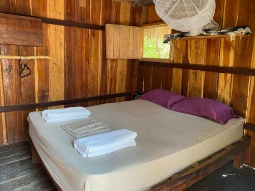 奥尔沃克斯岛Balam Camping & cabañas的木制房间的一个床位,上面有毛巾
