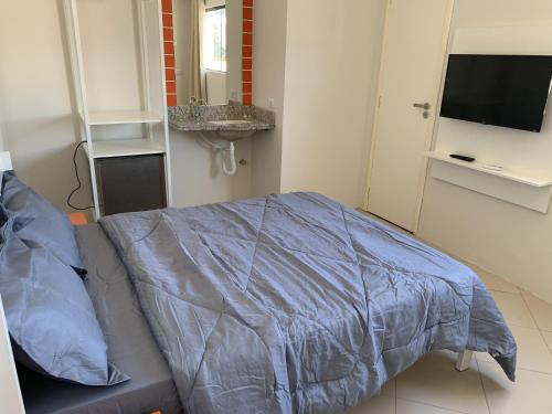 北茹阿泽鲁Senhor Hotel的一间卧室配有一张带蓝色棉被的床