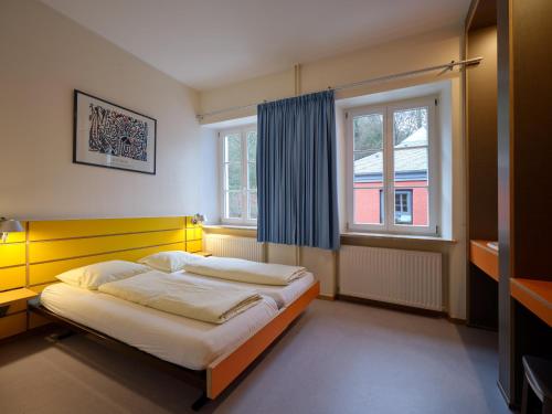 拉罗谢特拉罗谢特青年旅舍的一间卧室配有一张带黄色床头板的床和窗户