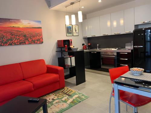 都灵CasaBella Inalpi Arena的一间带红色沙发的客厅和一间厨房