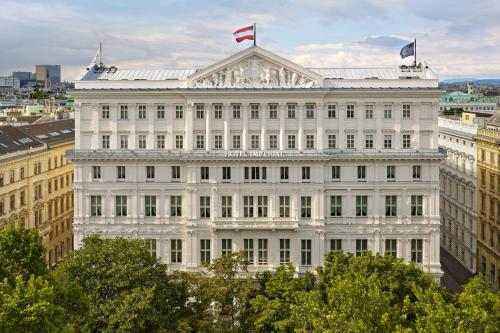 维也纳Hotel Imperial, a Luxury Collection Hotel, Vienna的上面有旗帜的白色建筑