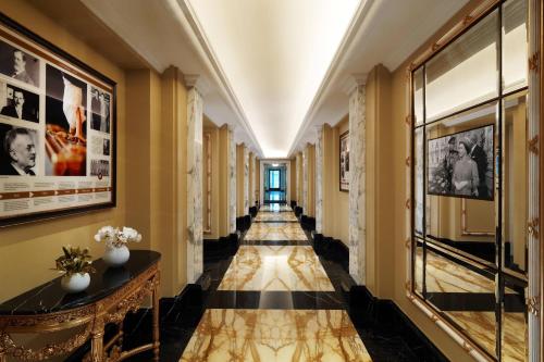 维也纳Hotel Imperial, a Luxury Collection Hotel, Vienna的走廊设有黄色的墙壁和黑白的瓷砖地板