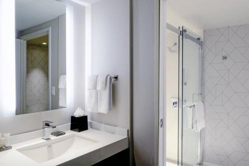 长滩长滩万豪酒店的白色的浴室设有水槽和淋浴。