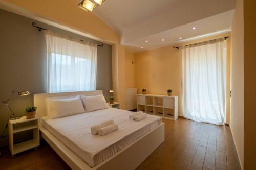 帕莱弗齐亚Phoceus Poolfront Grande Villa的一间卧室配有一张大床和两条毛巾