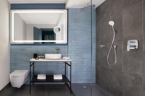 米兰Sheraton Milan San Siro的一间带卫生间、水槽和镜子的浴室