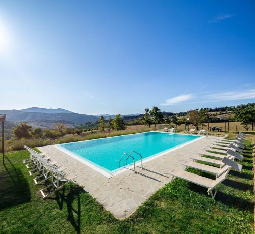 毕威格利亚努Residenza le Colline del Paradiso的一个带躺椅的游泳池和一个游泳池