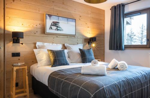 艾姆拉普拉涅TERRESENS - Le Snoroc的一间卧室设有一张带木墙的大床
