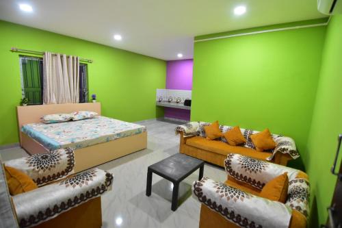 SibsāgarHira Panidihing Homestay的一间卧室设有绿色的墙壁和一张床及椅子