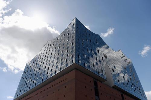 汉堡威斯汀汉堡酒店的一座高大的蓝色建筑,背后是天空