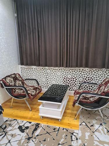 苦盏Апартамент в центре города Худжанд的客厅配有一张沙发、一张桌子和两把椅子