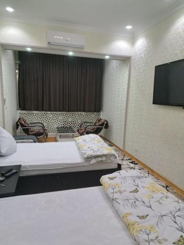 苦盏Апартамент в центре города Худжанд的酒店客房设有两张床和一台平面电视。