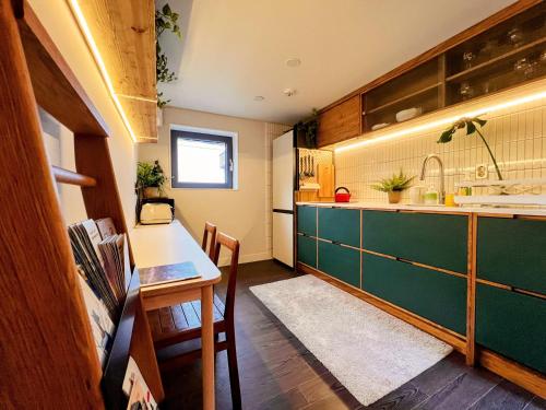 首尔HHZib, homestay on a hill in the heart of Seoul的厨房配有绿色的柜台和桌子