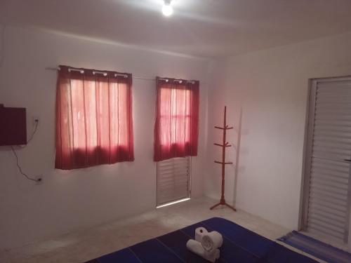 因巴塞Pousada Sol de Imbassai的客厅配有红色窗帘和电视