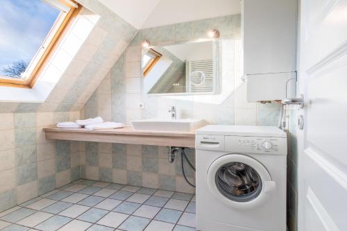 欧巴德伍斯图Ferienhaussiedlung Strandperlen Buchenhof 2a (Typ VIII)的一间带洗衣机和水槽的浴室