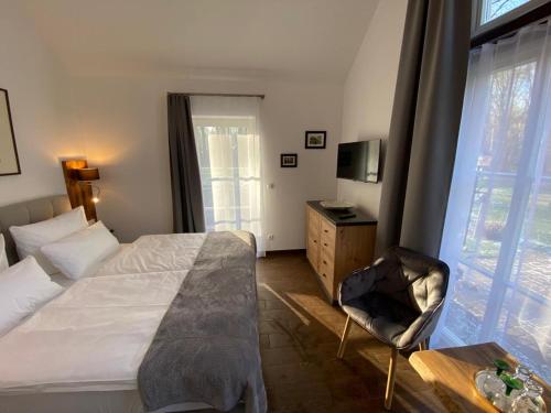 KaupenFerienhof Bludnik的卧室配有床、椅子和窗户。